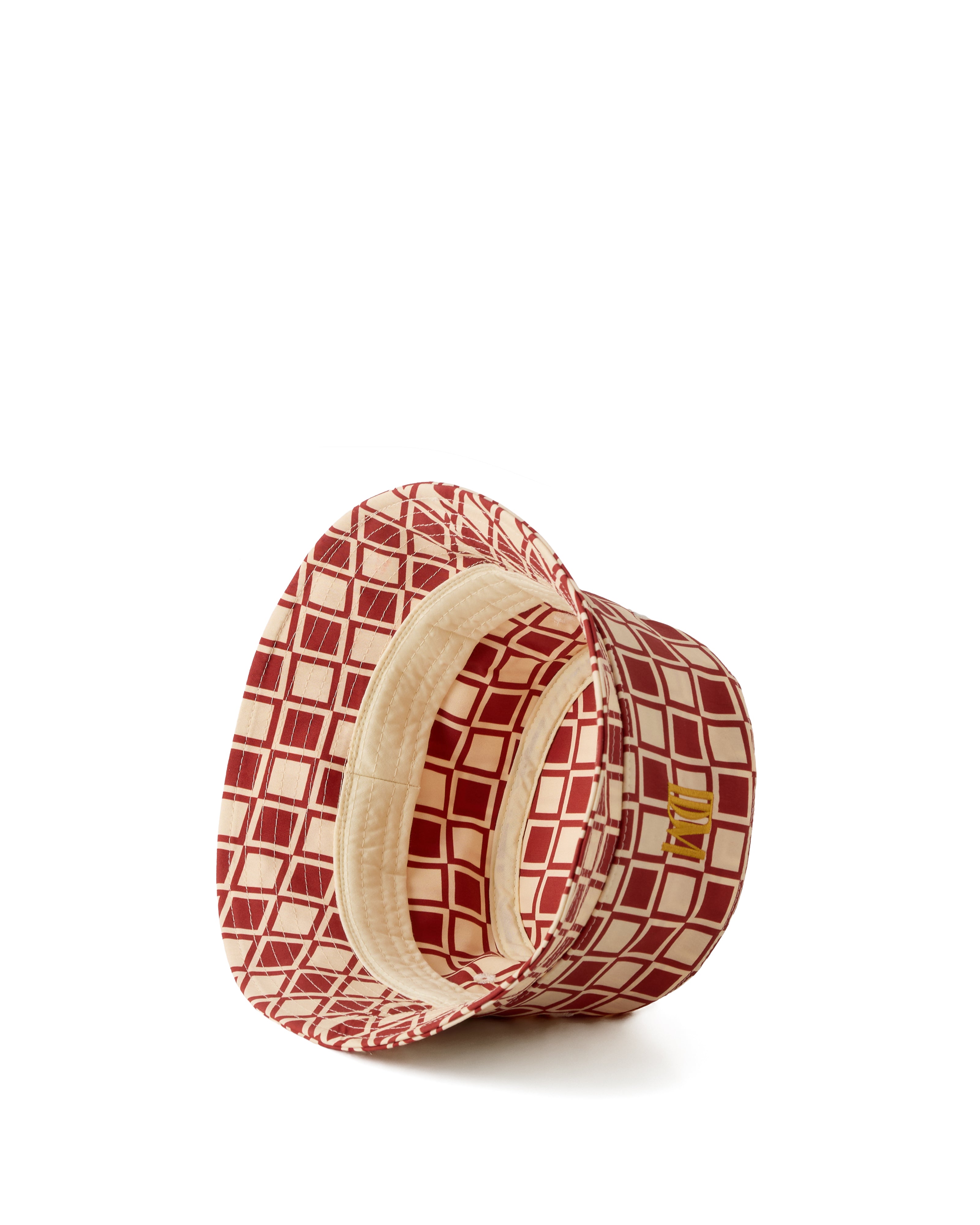 The Bucket Hat - Rouge by Dandy Del Mar is displayed upside down on a white background, featuring a red and beige patterned wide brim.