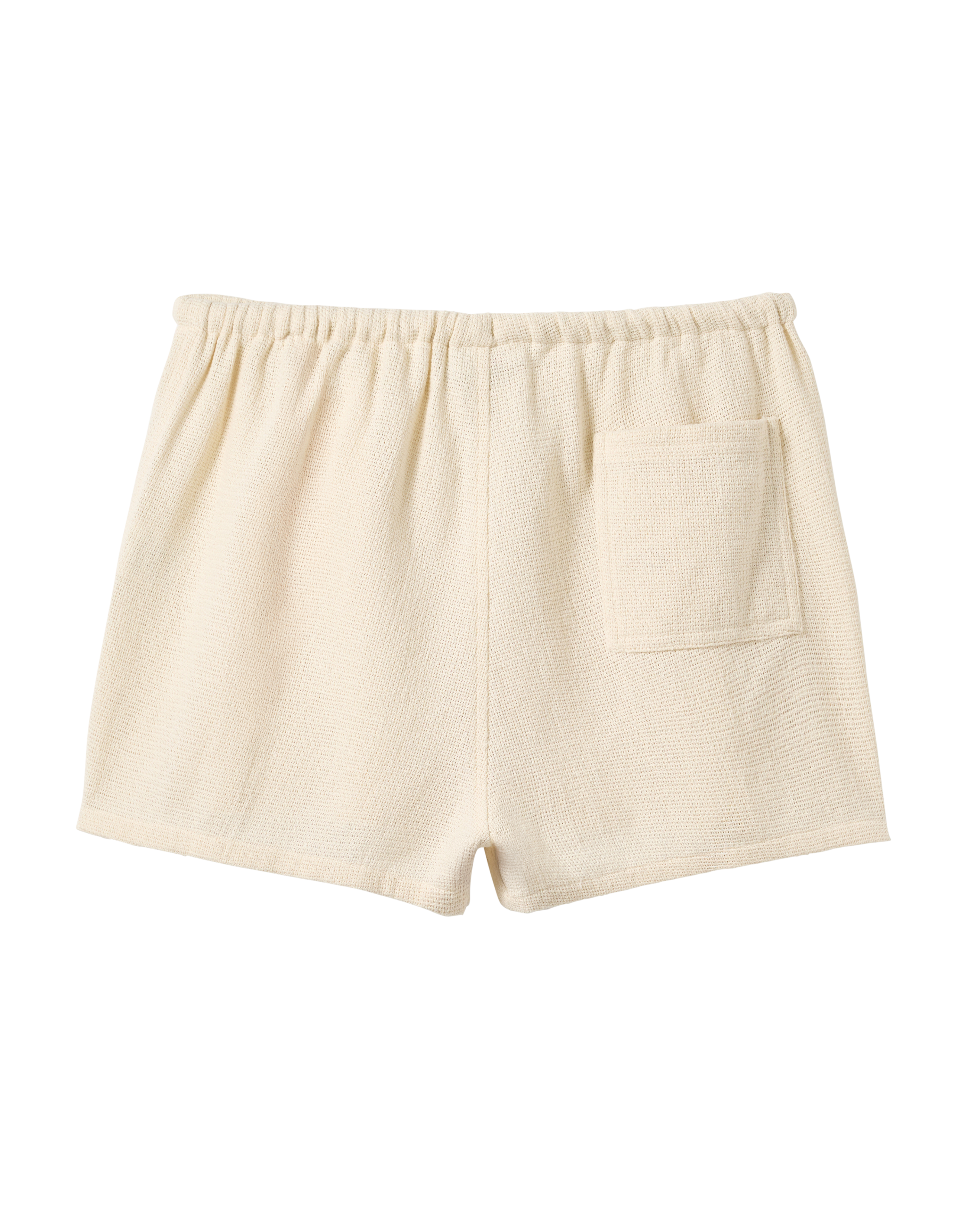 The Sevilla Short - Scallop by Dandy Del Mar: off-white textured shorts featuring an elastic waistband and single back pocket, shown against a plain black background.