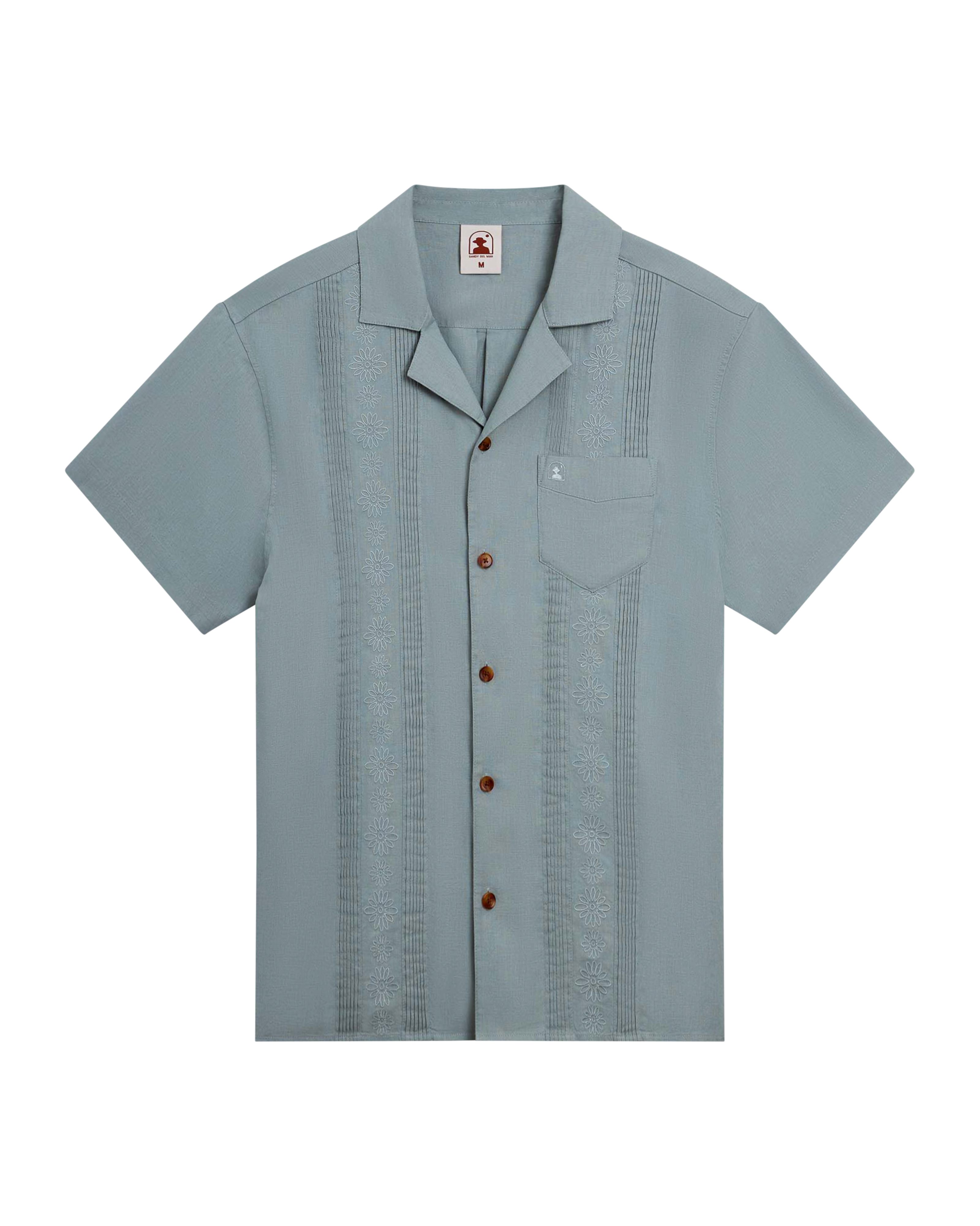 The Brisa Linen Shirt - Abalone by Dandy Del Mar features a light gray hue, coconut shell buttons, front pocket, and subtle vertical embroidered patterns on both sides of the front.