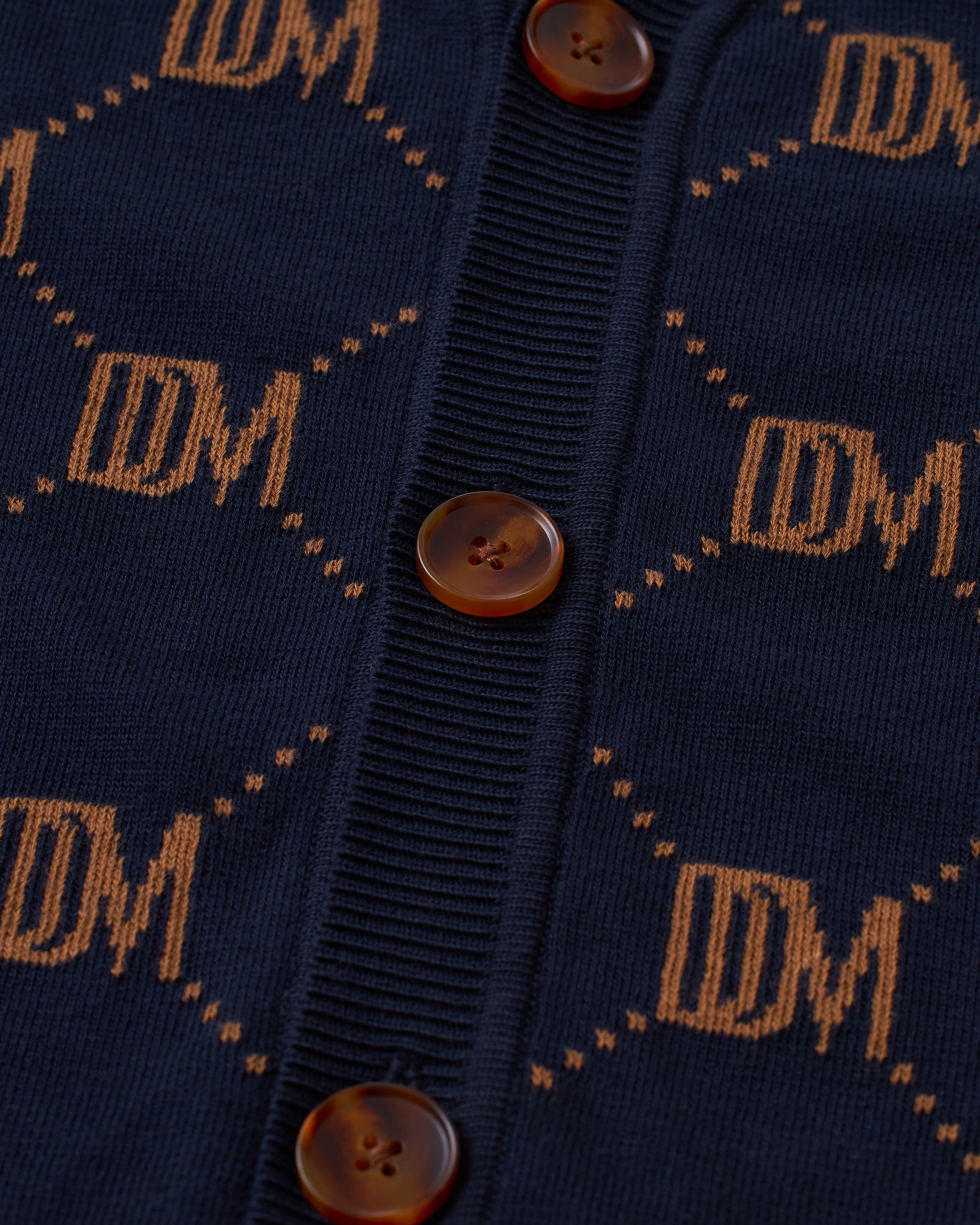 A close up of The Castello Cardigan - Abyss by Dandy Del Mar with floral accents.