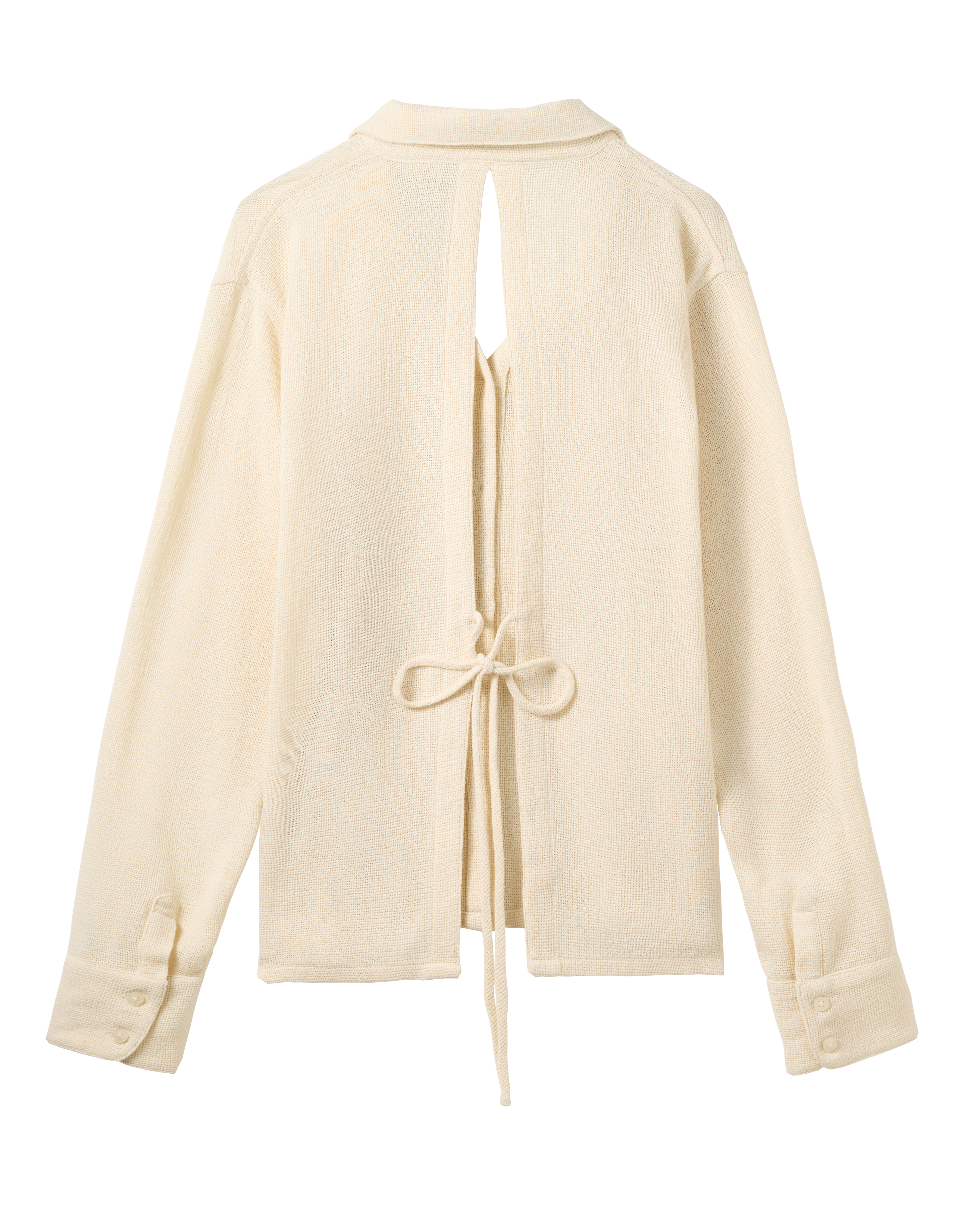 The Sevilla Top - Scallop by Dandy Del Mar: a cream long-sleeve shirt with a back slit, tie waist closure, and buttoned cuffs, shown flat on a black background.