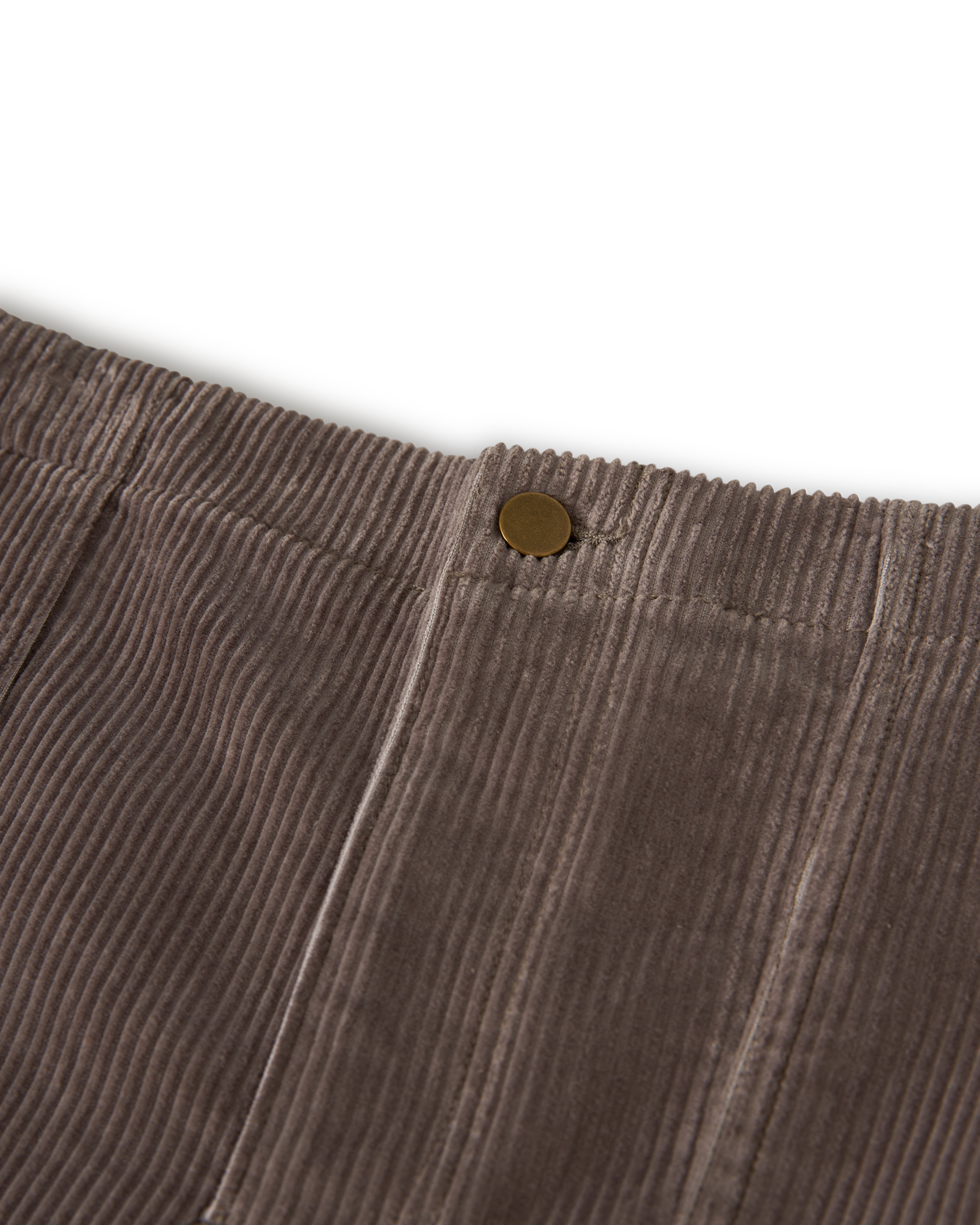 Close-up of The Corsica Corduroy Short in Argento by Dandy Del Mar, featuring a brown corduroy fabric with a brass button on the waistband.