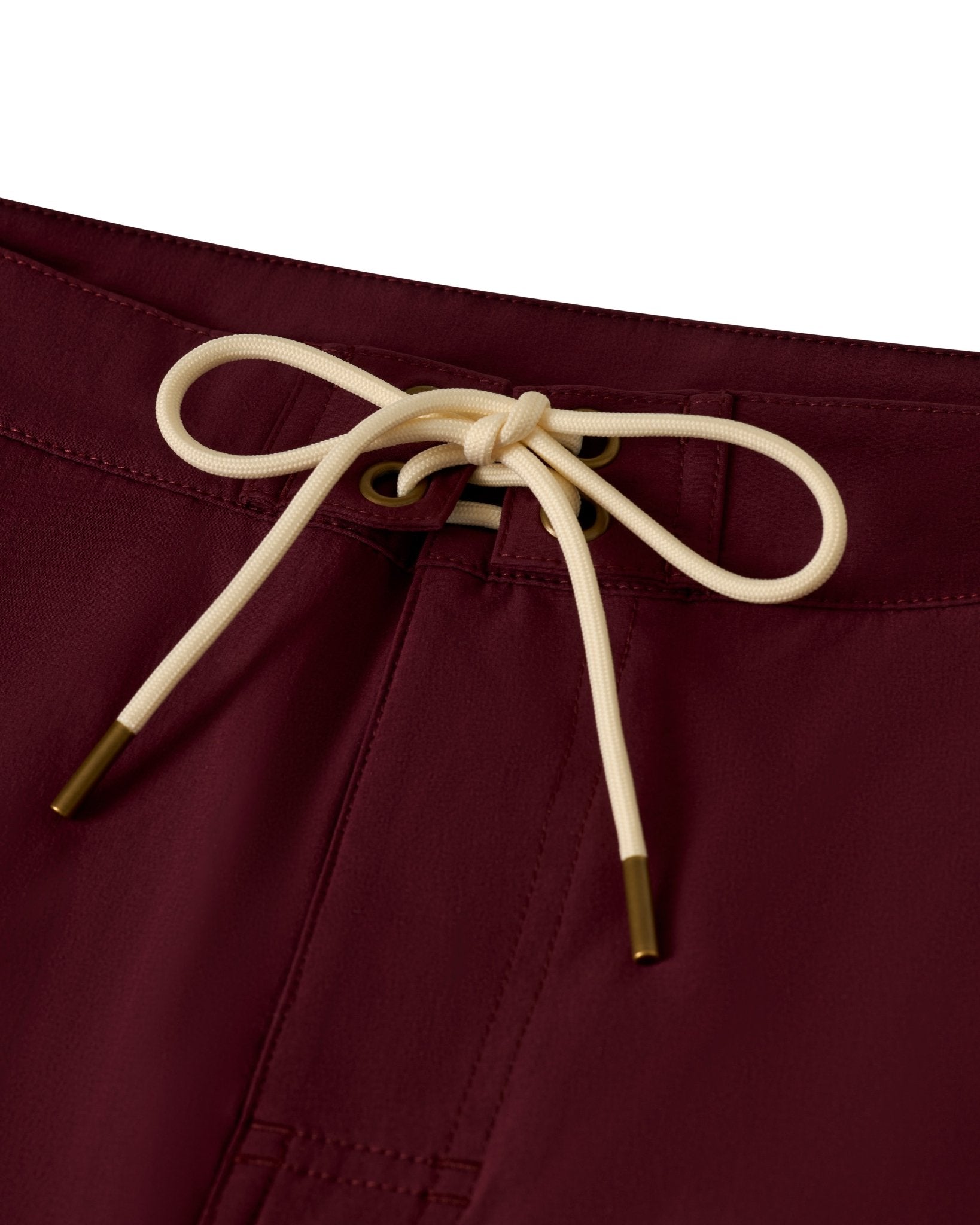 Close-up of The Stirata Swim Shorts - Bordeaux by Dandy Del Mar, featuring a maroon waistband with a cream drawstring tied in a bow and metal-tipped 4-way stretch string ends.
