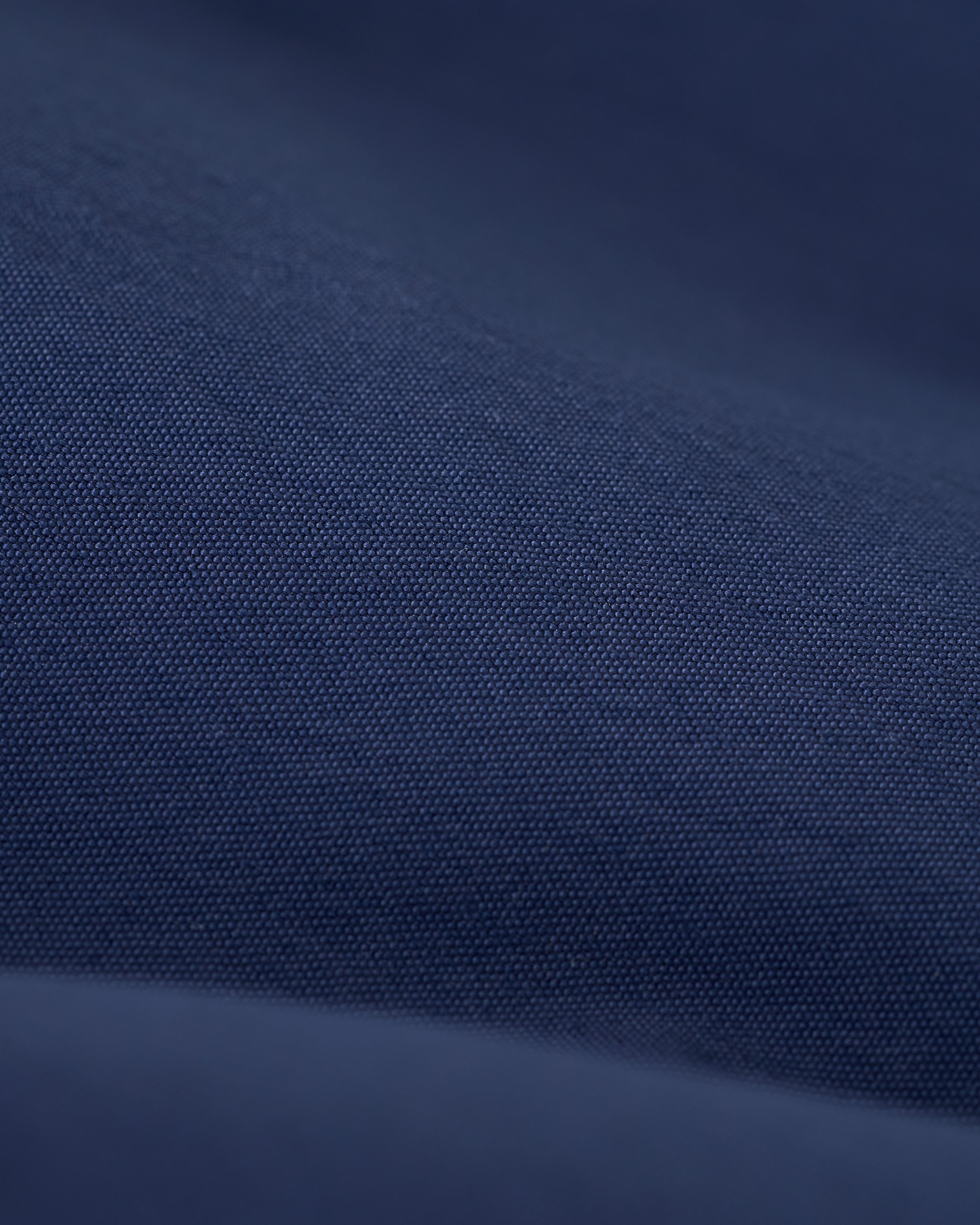 Close-up of dark blue fabric with a smooth, fine texture reminiscent of the micro mesh liner in The Ventura Volley Short - Anchor by Dandy Del Mar.