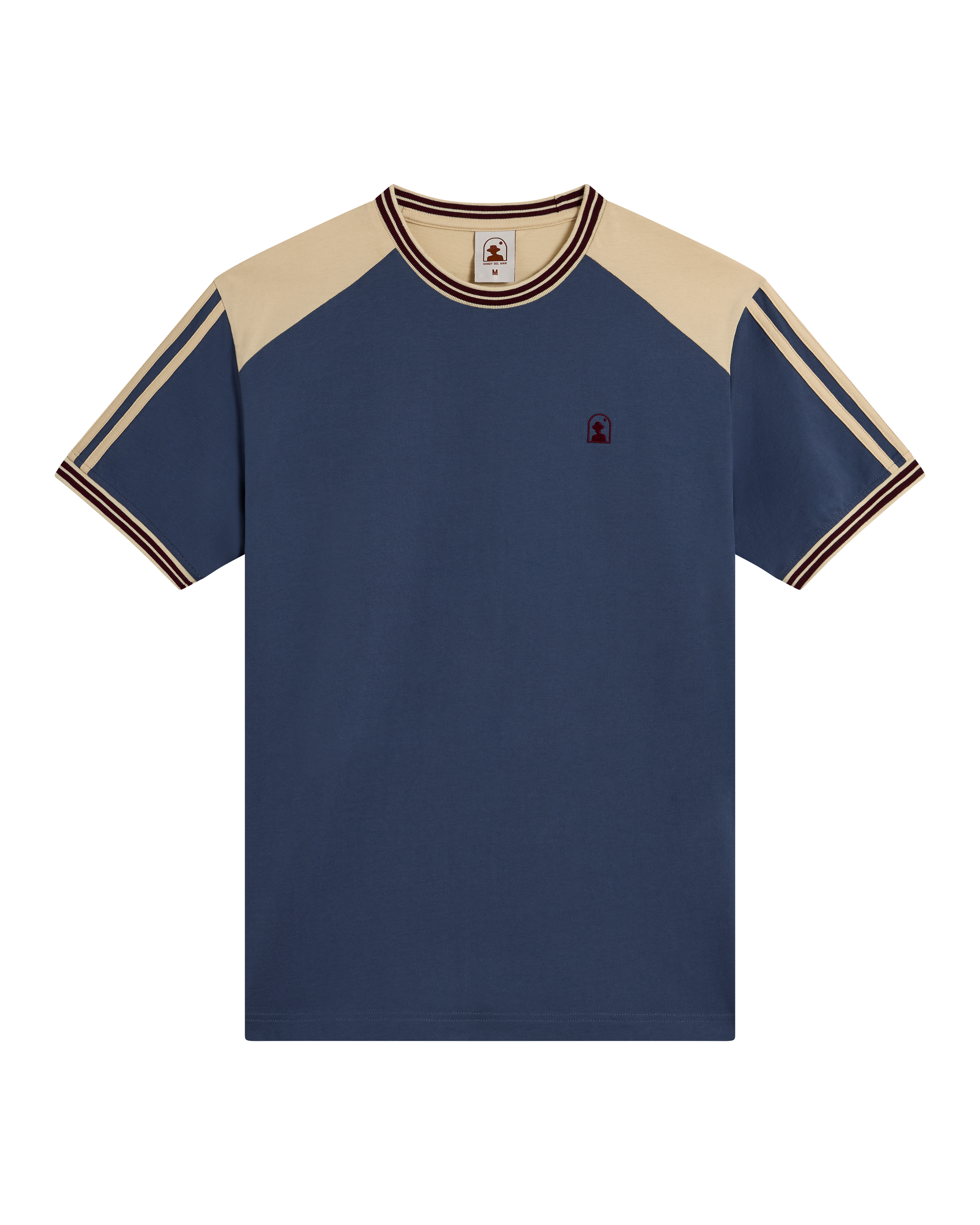 The Nassau Tee - Moontide by Dandy Del Mar is a soft cotton jersey tee with a navy body, beige raglan sleeves, striped trim on sleeves and collar, and an embroidered logo on the left chest.