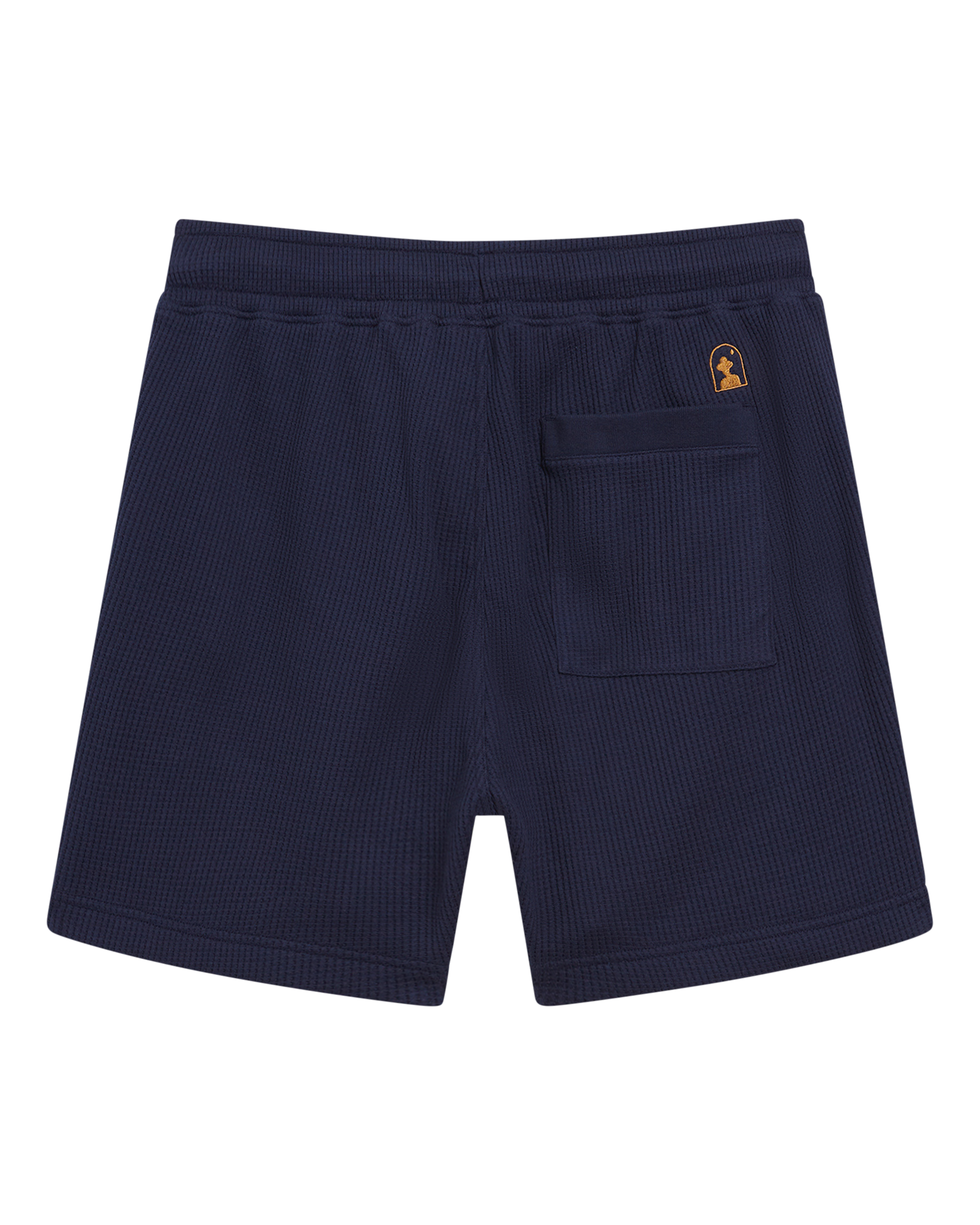 The Cannes Short - Luxe Navy by Dandy Del Mar is crafted from waffle knit, featuring an elastic waistband, a single back pocket, and a small gold logo patch above the pocket.