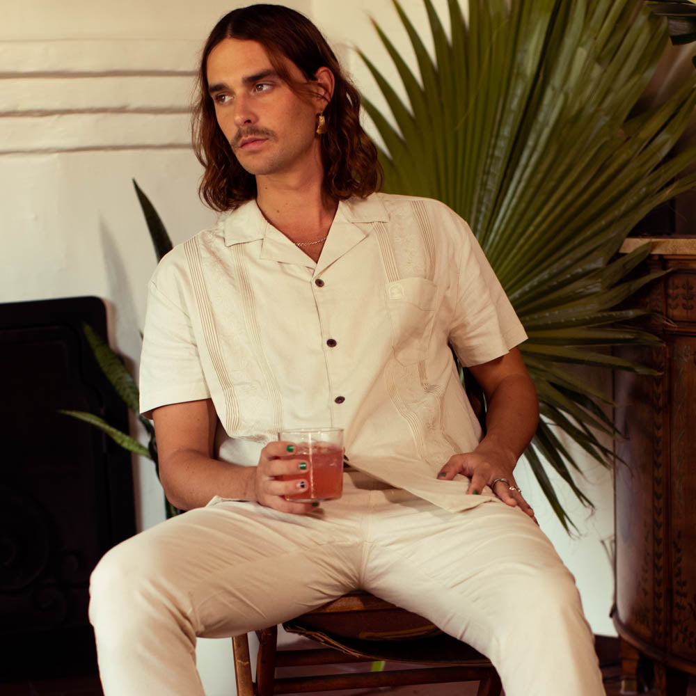 A man sitting on a chair holding a drink.