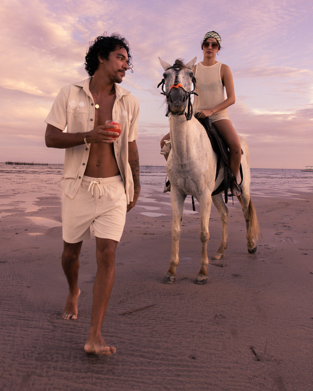 man in the Alabaster Gaucho Set on beach with a woman riding a horse