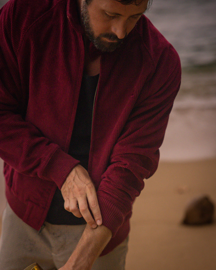 A man wearing a Dandy Del Mar Corsica Jacket - Sangria.