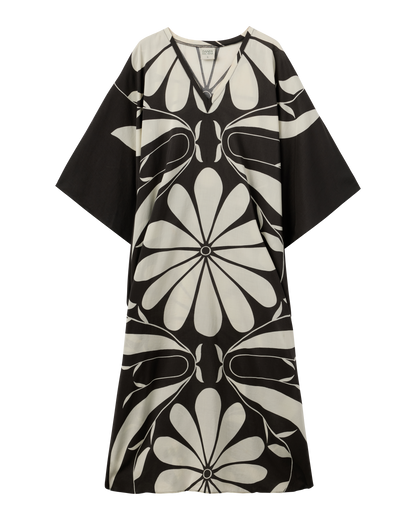 The Tropea Kaftan - Albatross by Dandy Del Mar is a loose-fitting black dress with wide sleeves, a bold white floral pattern, and a V-shaped neckline.
