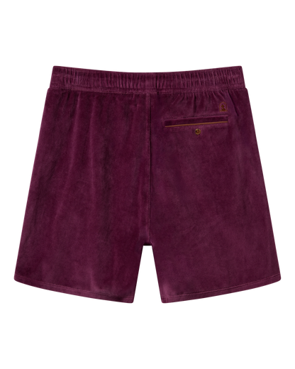 The Rio Velour Short - Bordeaux by Dandy Del Mar features a back view with an elastic waistband and a single buttoned back pocket, offering comfort and style—perfect for athletic wear.