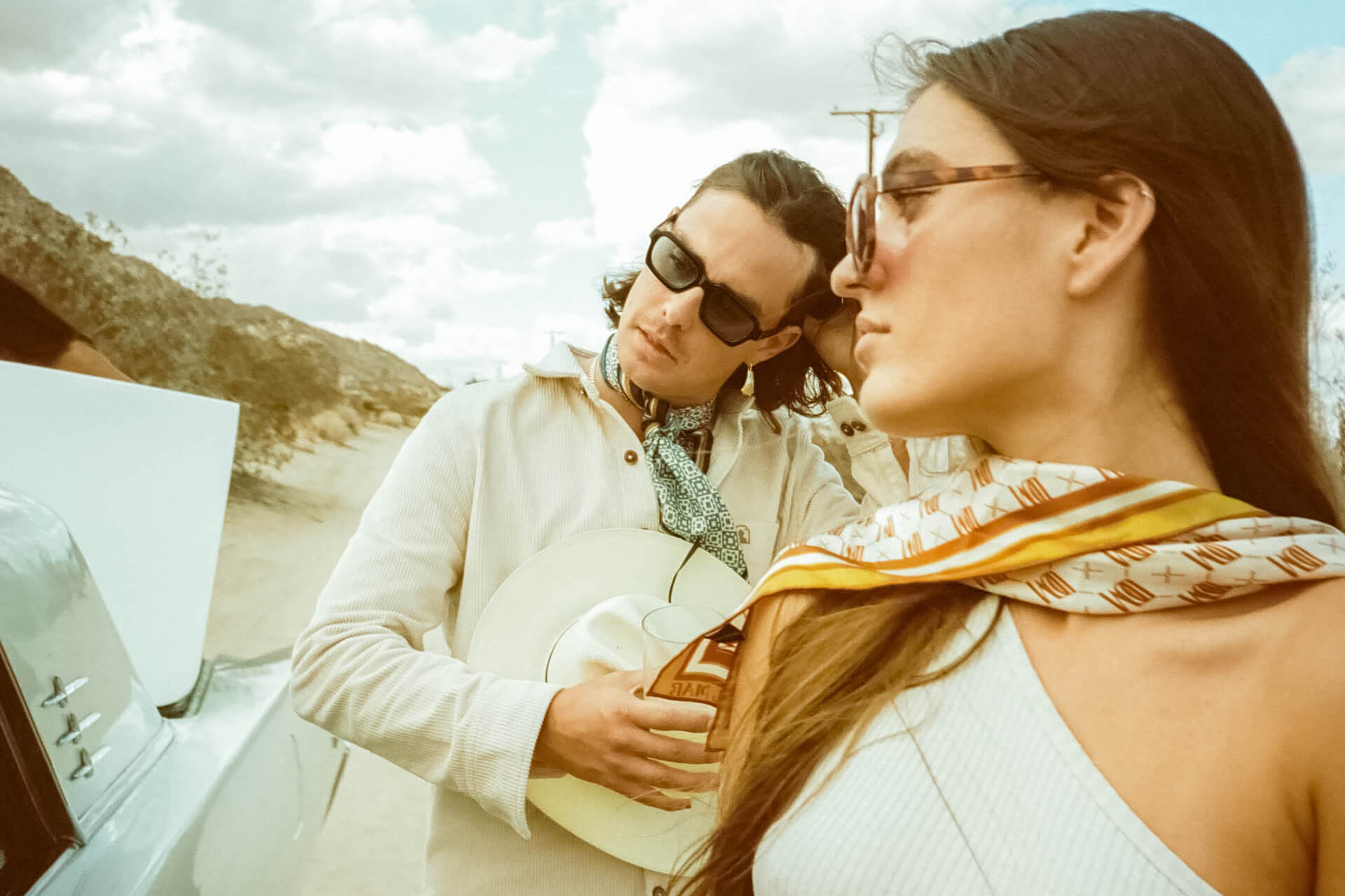 Couple in the desert by classic car with accessories