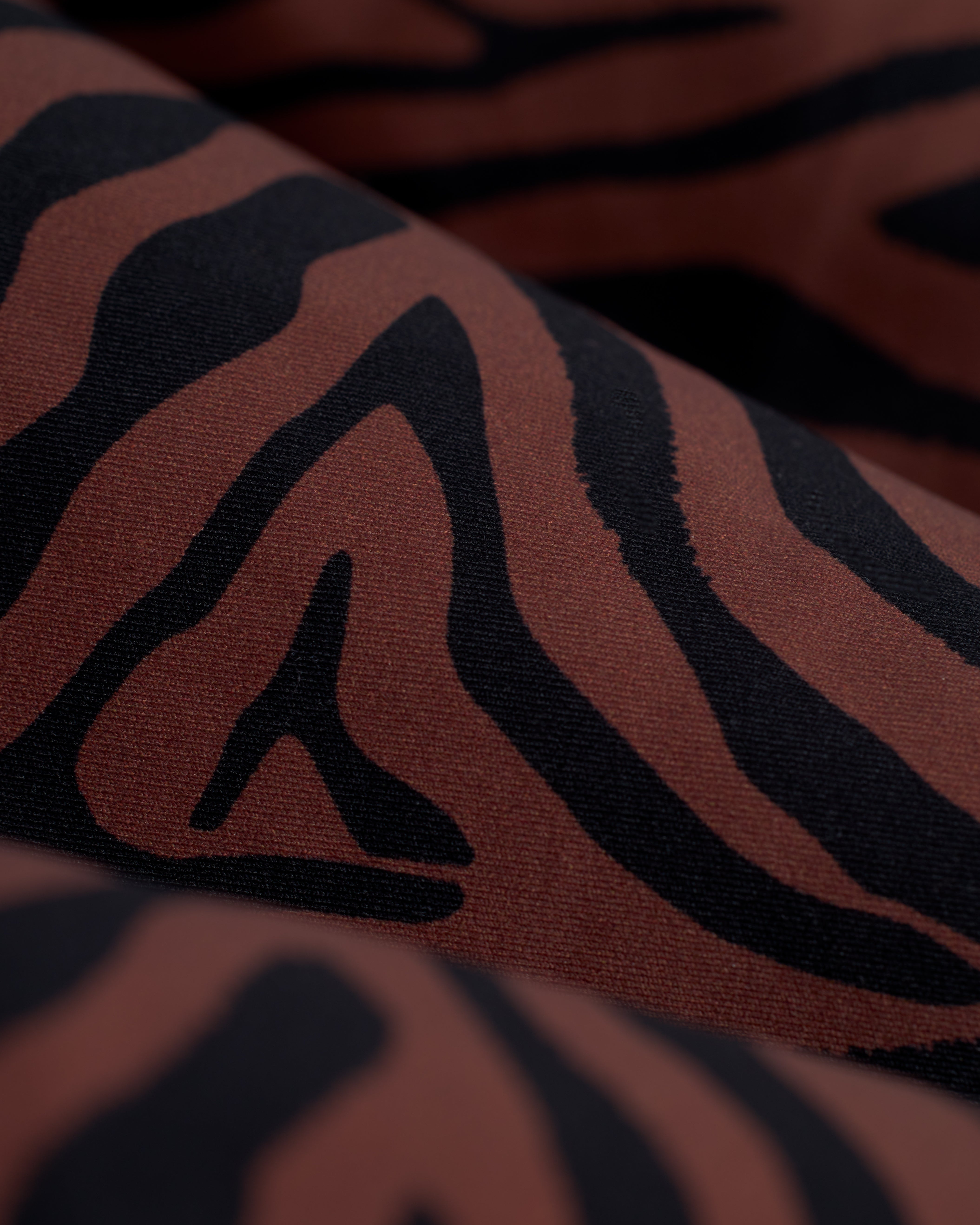 Close-up view of a fabric with a black and brown zebra stripe pattern, perfect for crafting The Gomera Bottom - Onyx by Dandy Del Mar.