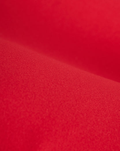 Close-up of red fabric, showcasing its texture and folds. The material appears smooth and vibrant in color, reminiscent of The Gomera Bottom - Pico by Dandy Del Mar with cheeky coverage.