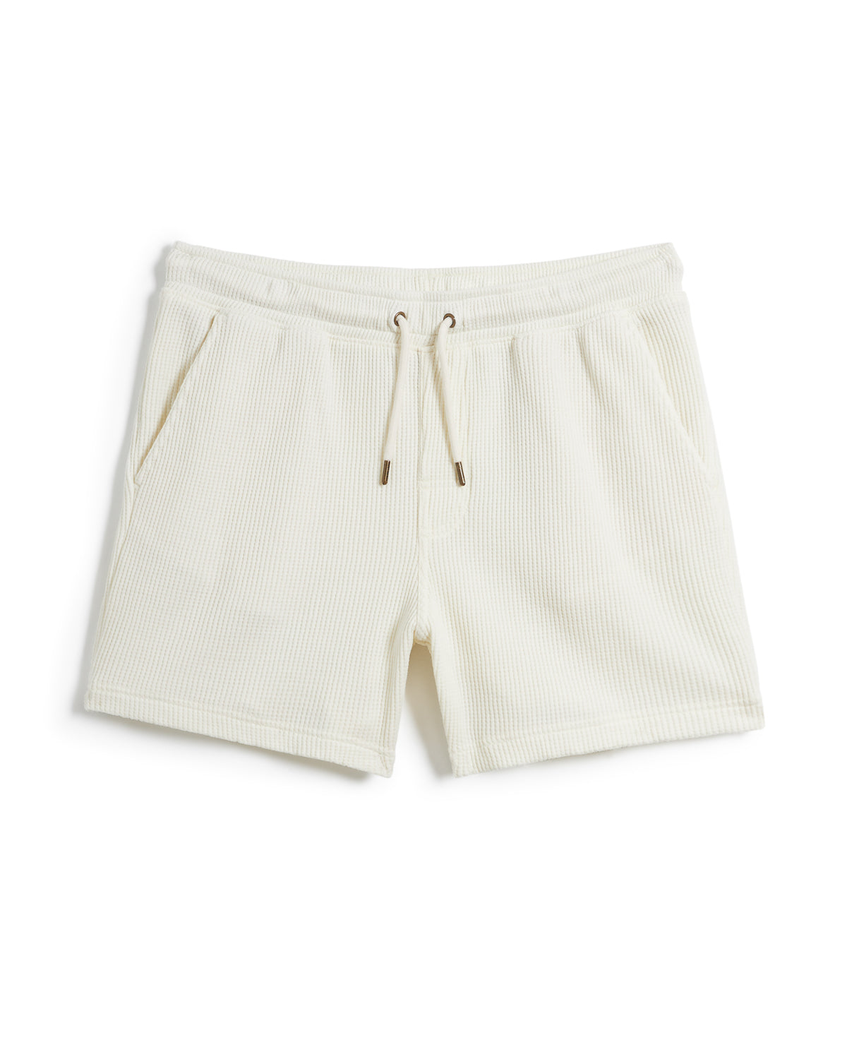 A pair of white Cannes shorts featuring an elastic waistband and a subtle striped texture, made from waffle knit fabric, displayed against a plain white background, is the **The Cannes Waffle Knit Shorts - Vintage Ivory** by **Dandy Del Mar**.