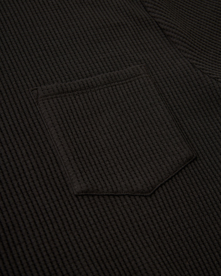 A close up of The Cannes Tee - Albatross from Dandy Del Mar, a black t-shirt with a pocket.