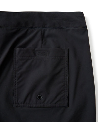 Close-up of The Cavoli Swim Shorts - Onyx by Dandy Del Mar, featuring black 4-way stretch fabric and a rectangular back pocket with a flap and small metal grommet at the bottom.