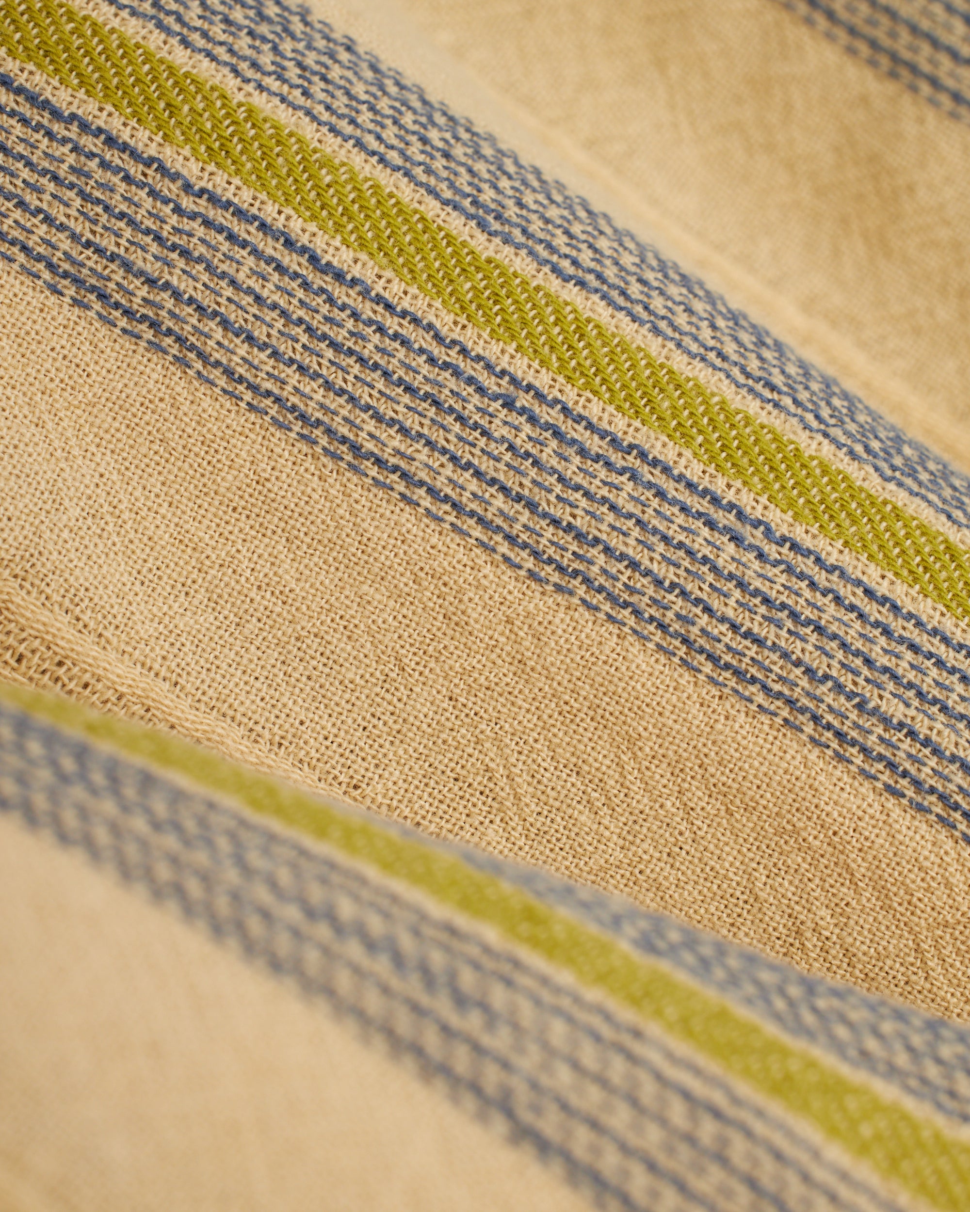 A close up of The Corralejo Short - Ginger from Dandy Del Mar, a beige and blue striped cloth.