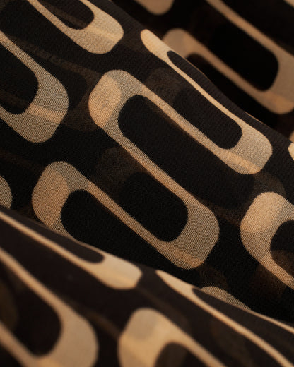 A close up of The Curacao Chiffon Dress - Albatross by Dandy Del Mar, a black and beige fabric.