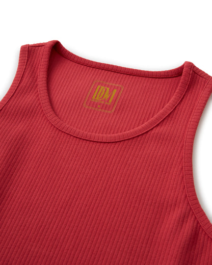 A Dandy Del Mar Milan Rib Tank - Currant with a gold logo on it.