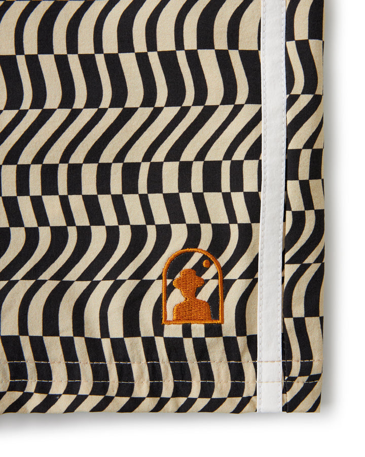 A black and white striped towel with an orange Dandy Del Mar logo, perfect for use at the beach or pool.