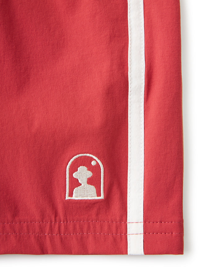 A water resistant Swimata Swim Short - Currant with a red color and white logo by Dandy Del Mar.