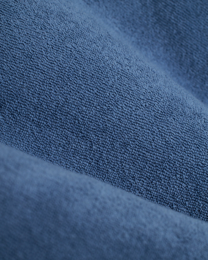 A close up of The Tropez Robe - Annapolis by Dandy Del Mar, a relaxed and comfy blue fabric.