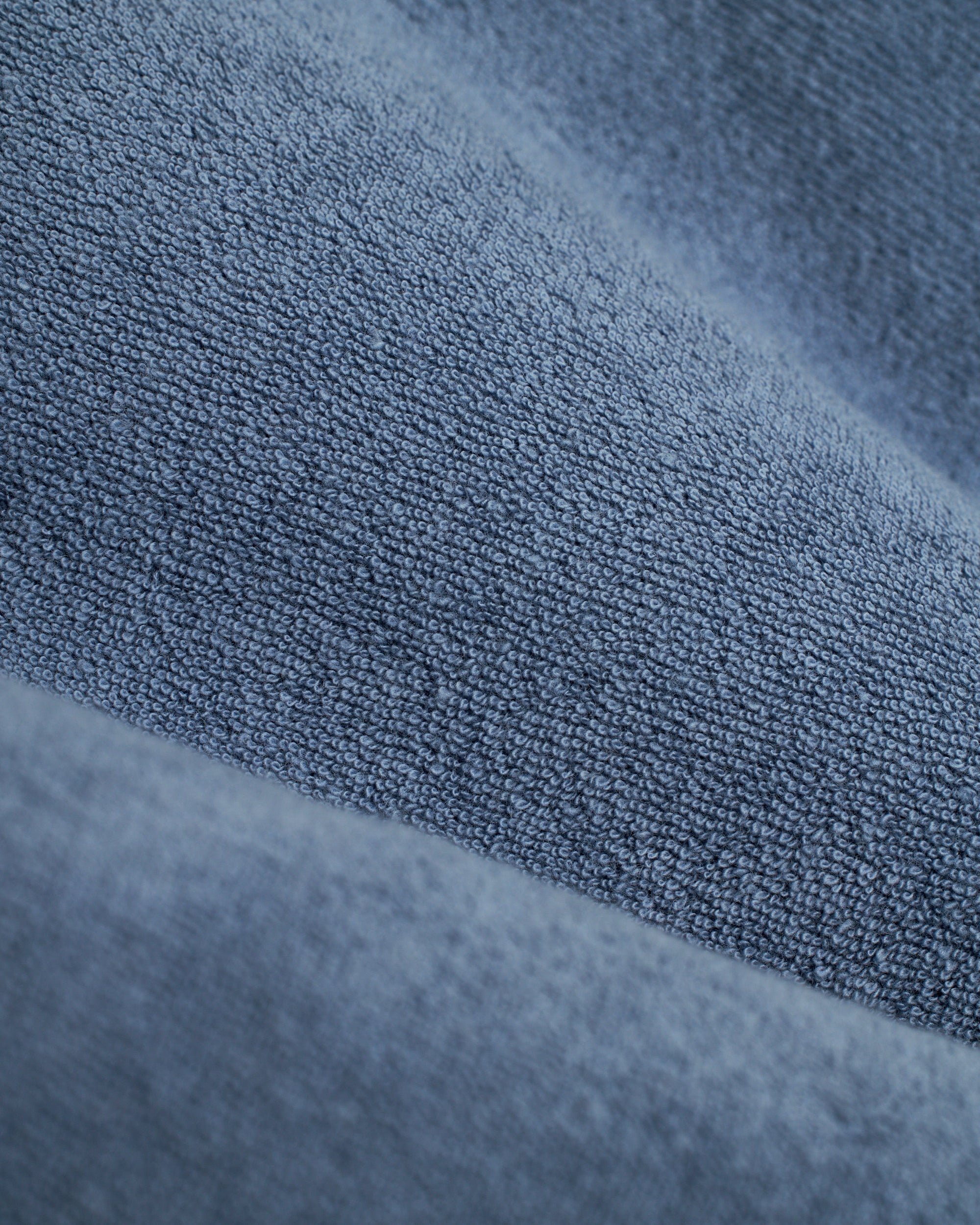 Close-up of The Tropez Shirt - Annapolis by Dandy Del Mar, showcasing its blue textured fabric made from premium terry cloth with small loops and a soft surface.