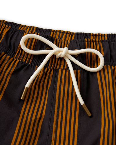Close-up of The Ventura Volley Shorts - Albatross by Dandy Del Mar, featuring vertical orange stripes, an elastic waistband, and a white drawstring with metal tips—ideal for men’s swimwear style.
