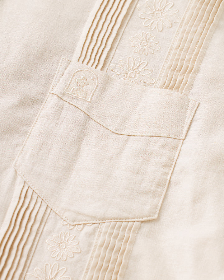 A close up of the Brisa Linen Shirt - Vintage Ivory by Dandy Del Mar with a pocket.