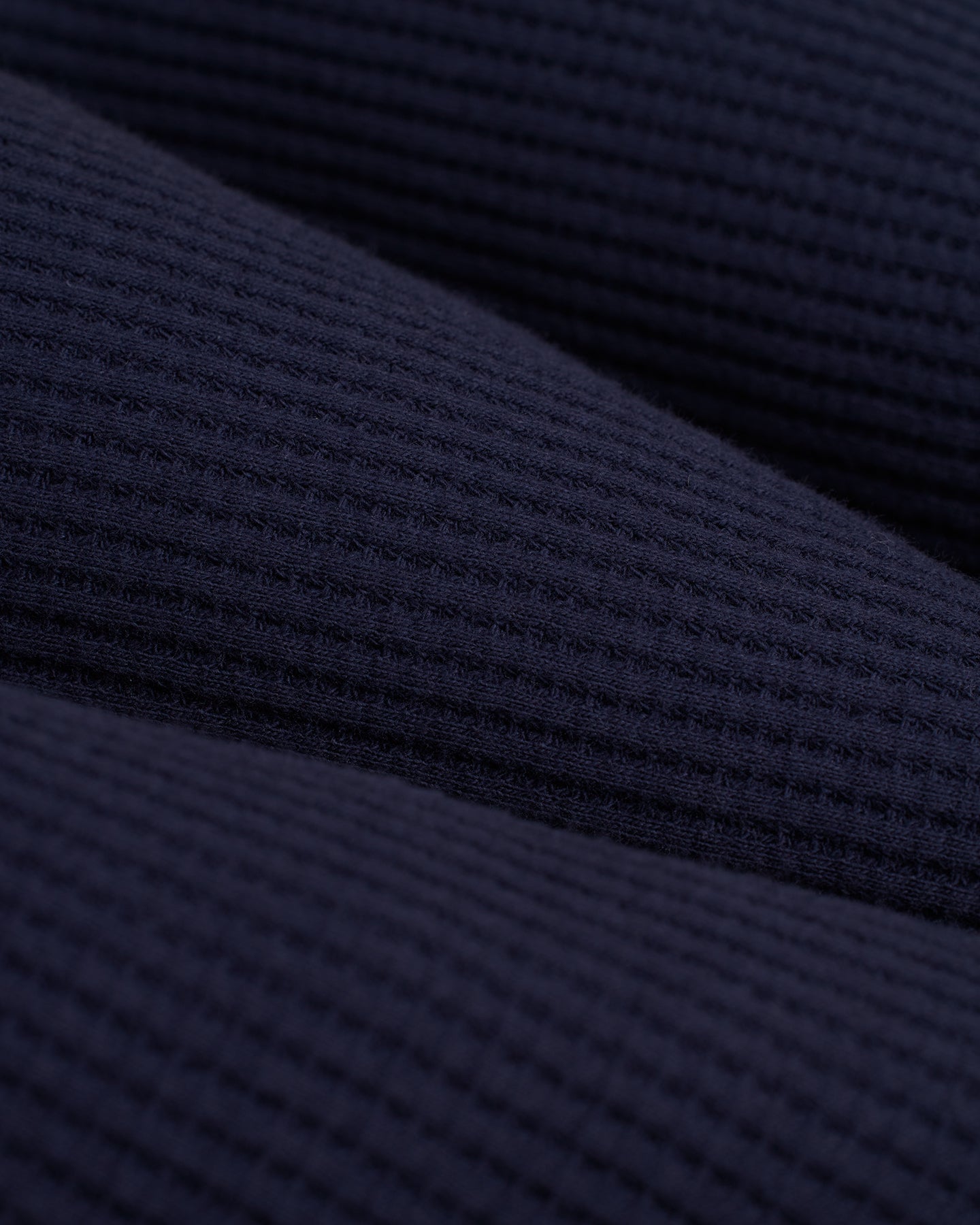 A close up of the Dandy Del Mar Cannes Robe - Luxe Navy, a dark blue knit fabric.