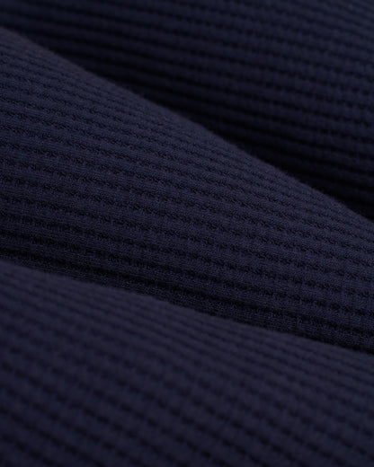 A close up of the Dandy Del Mar Cannes Robe - Luxe Navy, a dark blue knit fabric.