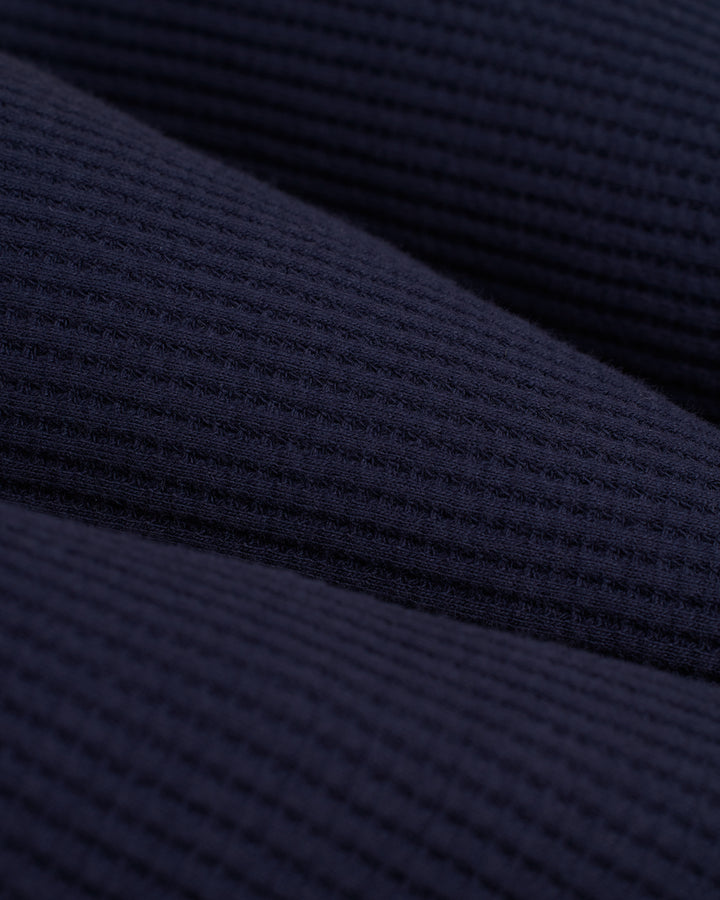 A close up of the Cannes Long Sleeve Tee - Luxe Navy by Dandy Del Mar.