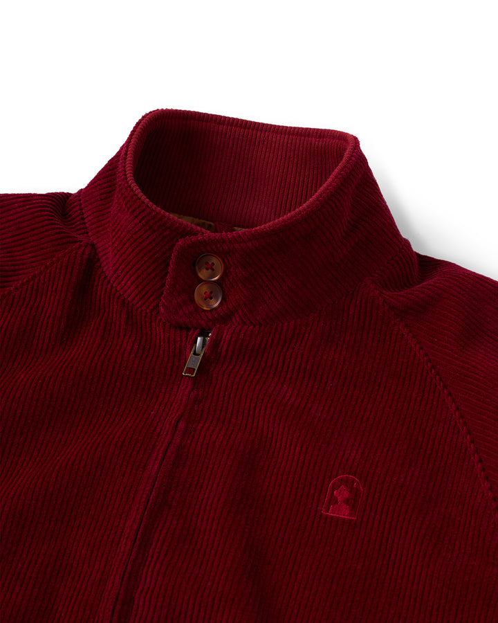 A red Corsica Jacket - Sangria by Dandy Del Mar with a logo on the front.