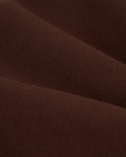 Close-up of The Marseille French Terry Pullover - Carajillo's brown fabric by Dandy Del Mar, showcasing the rich texture and subtle folds characteristic of French terry.