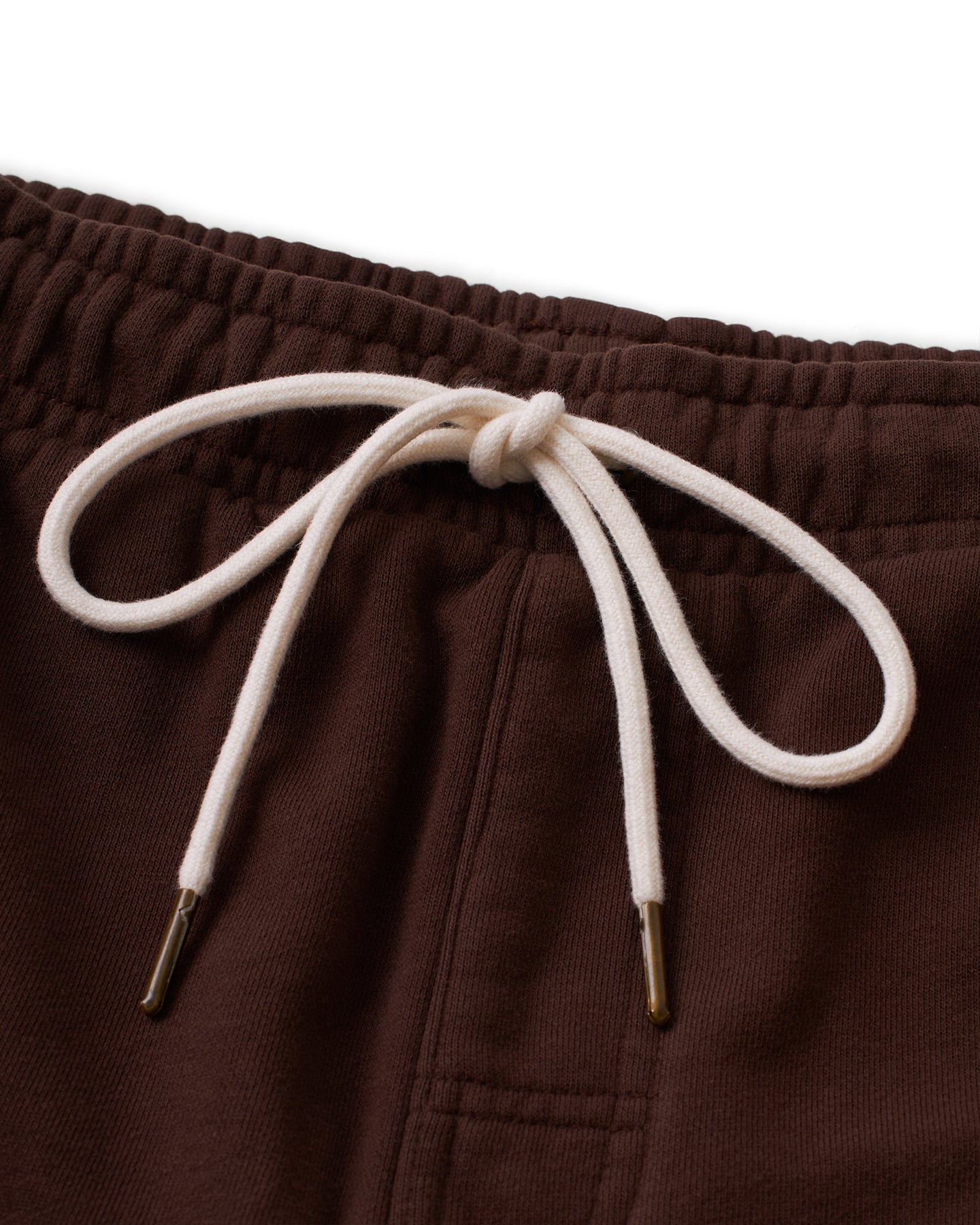 Close-up of The Marseille French Terry Short - Carajillo by Dandy Del Mar, featuring a white, knotted drawstring with brass-colored aglets at the waistband.