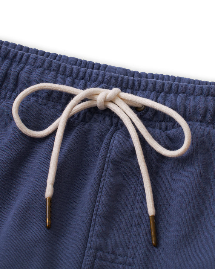 A pair of The Marseille Short - Moontide swim shorts with a gold tassel by Dandy Del Mar.