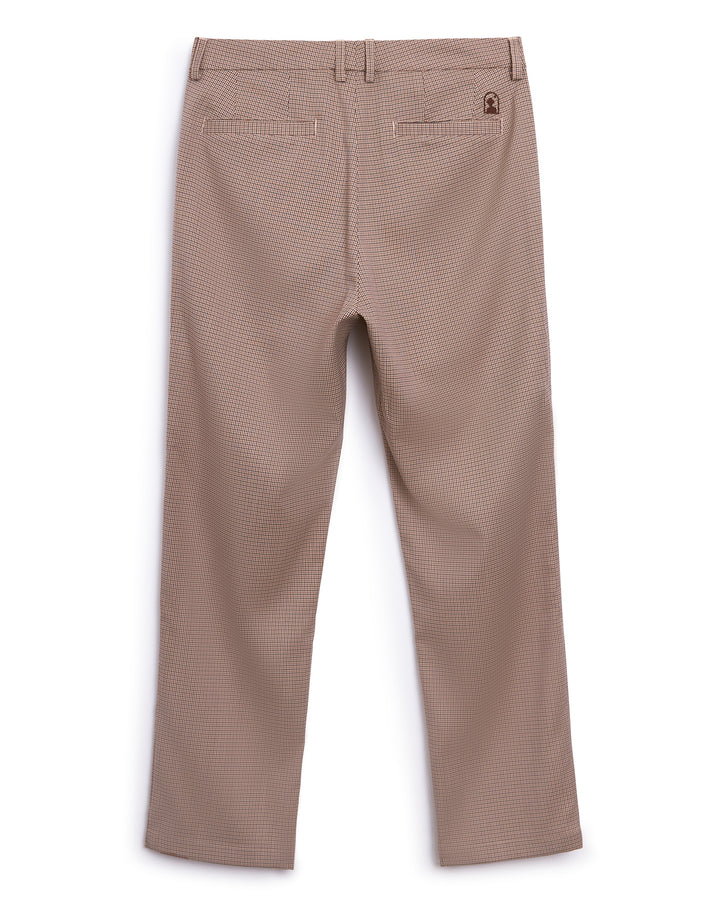A boy's Tresco Trouser in beige, made of Carajillo houndstooth cotton fabric by Dandy Del Mar.