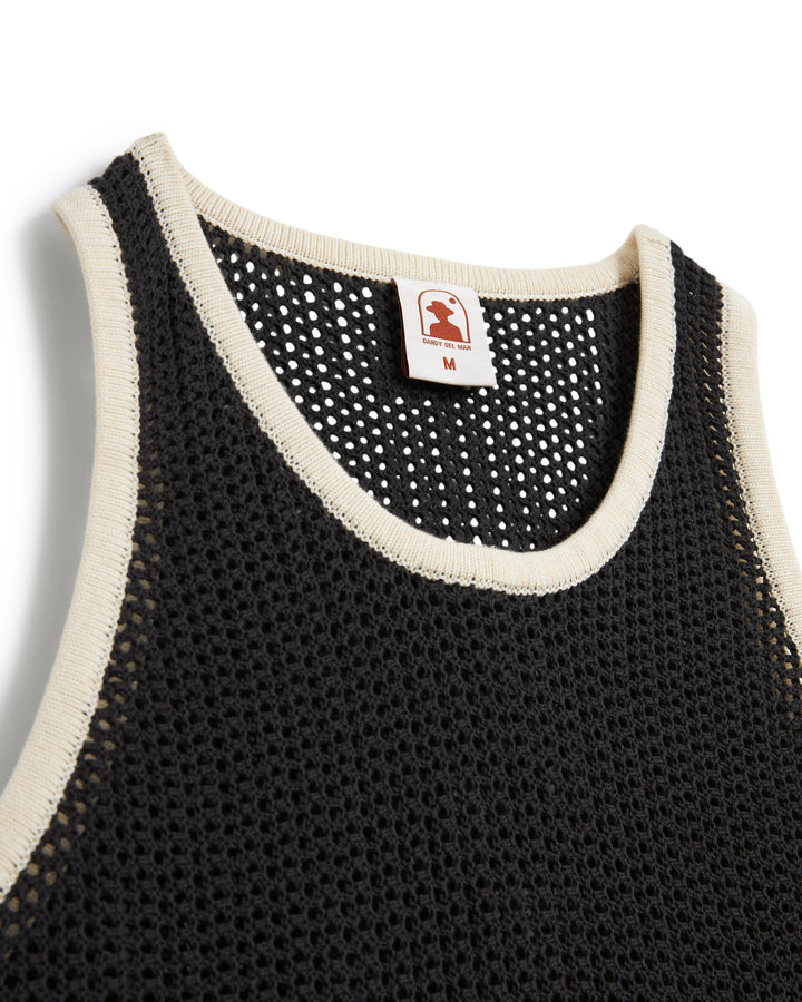Close-up of a black and white sports jersey neckline with a size tag, styled like The Dominica Crochet Tank by Dandy Del Mar.