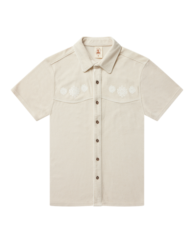 The Gaucho Terry Cloth Shirt - Alabaster by Dandy Del Mar is a short-sleeve, collared shirt in soft terry cloth, featuring white floral embroidery on the chest.