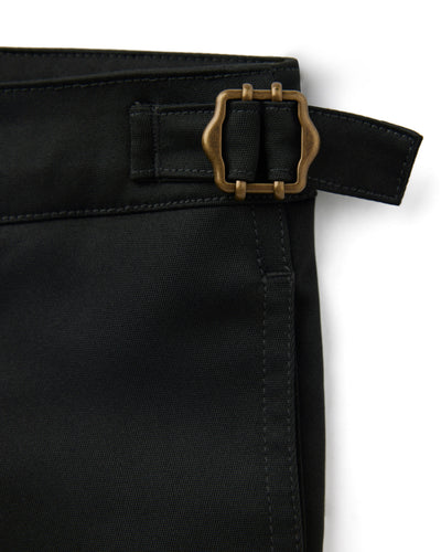Close-up of The Mallorca Swim-Walk Shorts - Onyx by Dandy Del Mar, showcasing black fabric, stitched seams, adjustable side fasteners, and a brass-colored buckle for a refined, versatile style.
