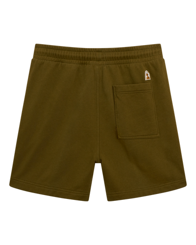 The Marseille French Terry Shorts in Arbequina by Dandy Del Mar feature an olive green hue, elastic waistband, right-side back pocket, and a small logo patch above the pocket, shown on a white background.