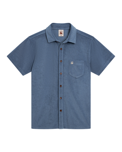 The Dandy Del Mar Tropez Terry Cloth Shirt - Annapolis features short sleeves, a chest pocket, and dark buttons. Its relaxed tailored fit in soft terry cloth is shown laid flat on a white background.