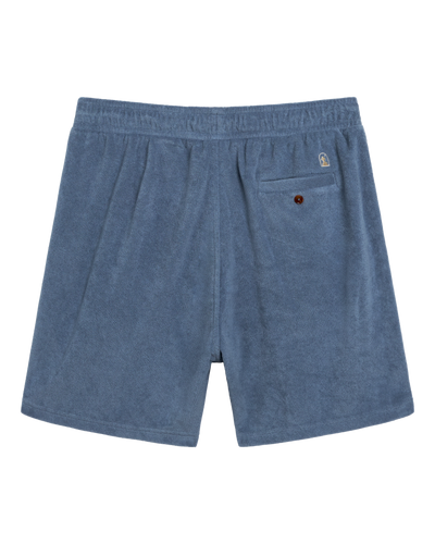 The Tropez Terry Cloth Shorts - Annapolis by Dandy Del Mar feature blue terry cloth, an elastic waistband, a buttoned back pocket with a logo patch, and evoke relaxed Côte d'Azur style, shown on a white background.