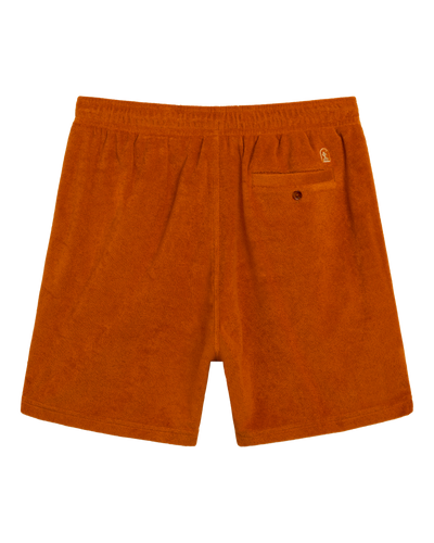 The Tropez Terry Cloth Shorts - Burnt Sienna by Dandy Del Mar, made from soft terry cloth, feature an elastic waistband, two side pockets, and a buttoned back pocket. Shown from the back on a white background.
