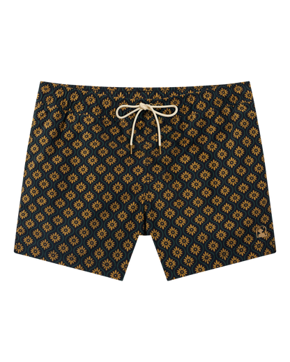 The Dandy Del Mar Ventura Volley Short in Oro Gardenia Print features a yellow floral geometric pattern, elastic waist, white drawstring, and micro mesh liner, shown flat on a black background.