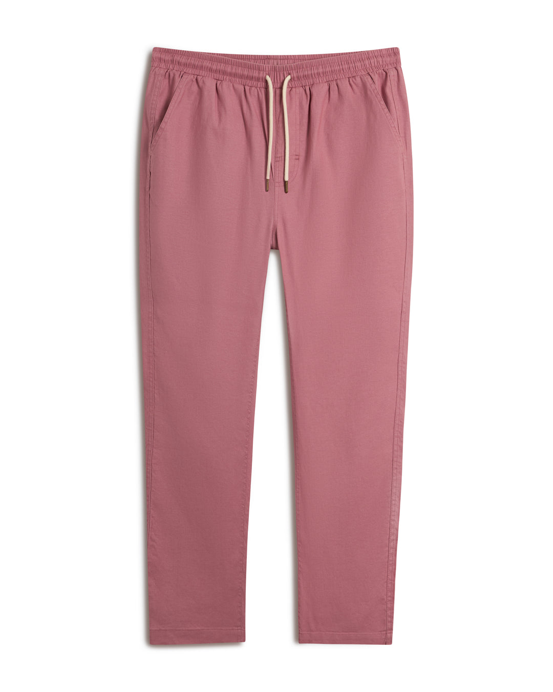 The Brisa Linen Pant - Dawn by Dandy Del Mar showcases a delightful pink color with an elastic waist and drawstring, complete with side pockets, set against a white backdrop. Ideal for vacation escapades.