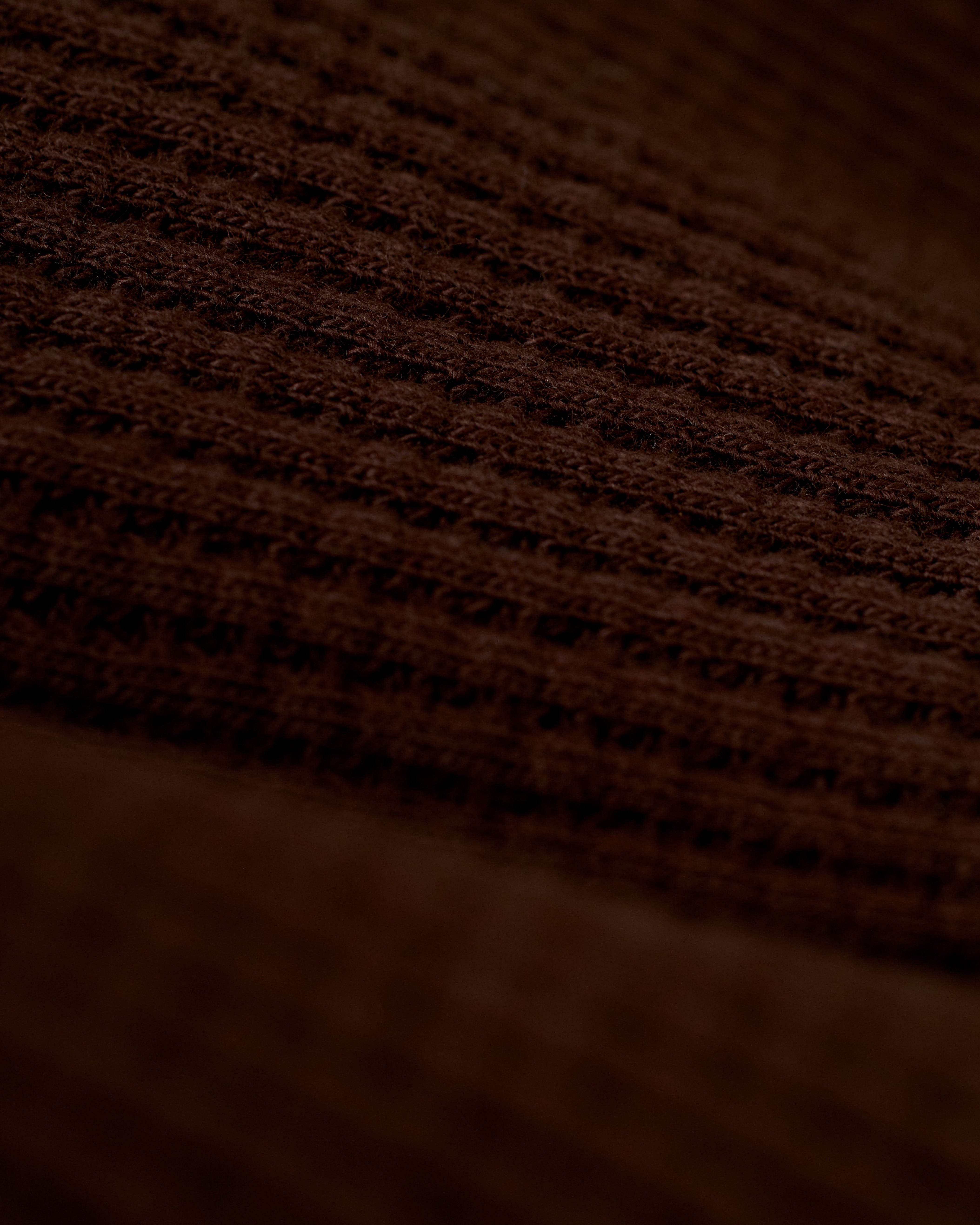 A close-up view of the brown 100% cotton fabric with a waffle weave pattern, reminiscent of the exquisite texture found in Dandy Del Mar's The Cannes Waffle Knit Robe - Carajillo.