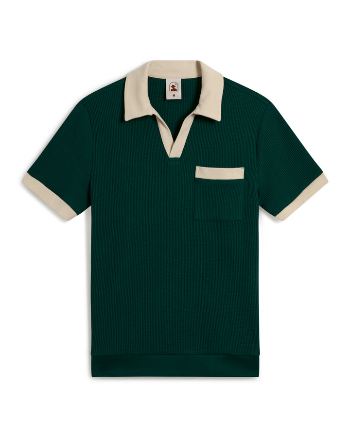 The Cannes Waffle Knit Shirt - Albero by Dandy Del Mar is a green short-sleeve polo with a beige collar and pocket trim, featuring a ribbed texture.