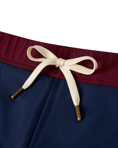 Close-up of The Cassis Square Cut Swim Brief - Anchor Bordeaux by Dandy Del Mar, showcasing a burgundy waistband and a white drawstring bow. Made from recycled polyester, this dark blue swim brief offers an elegant European fit.